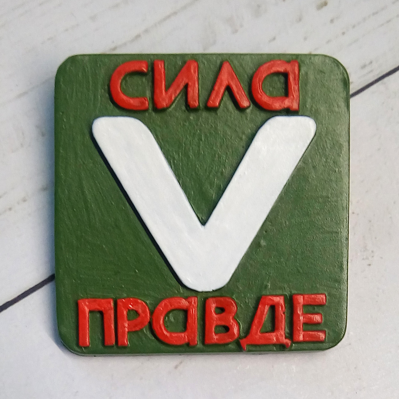 Значок v