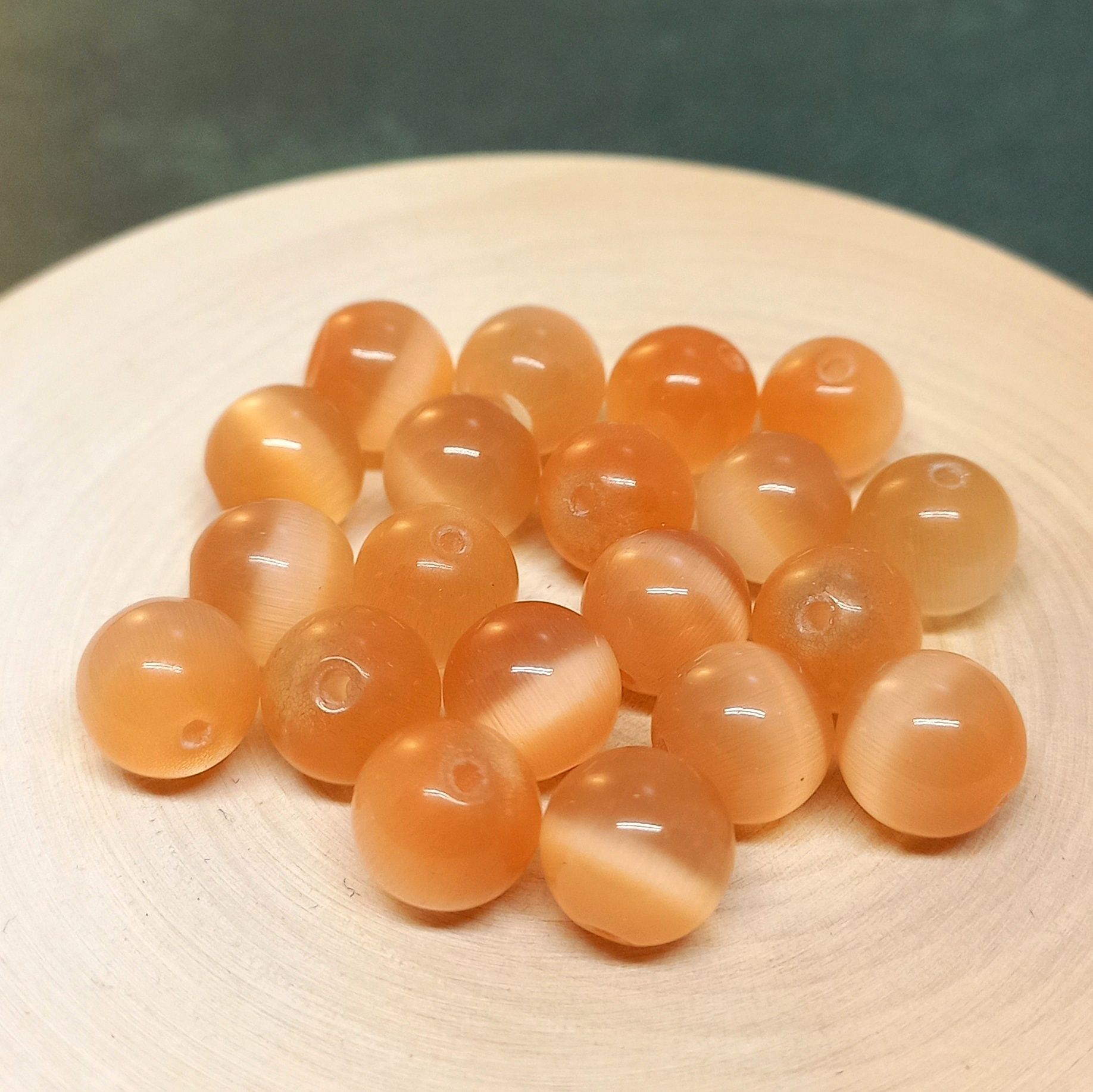 Бусы из кошачьего глаза. Макияж в персиковых оттенках. Абрикос на белом фоне. Персиковые тени для век. Оливковая косточка.