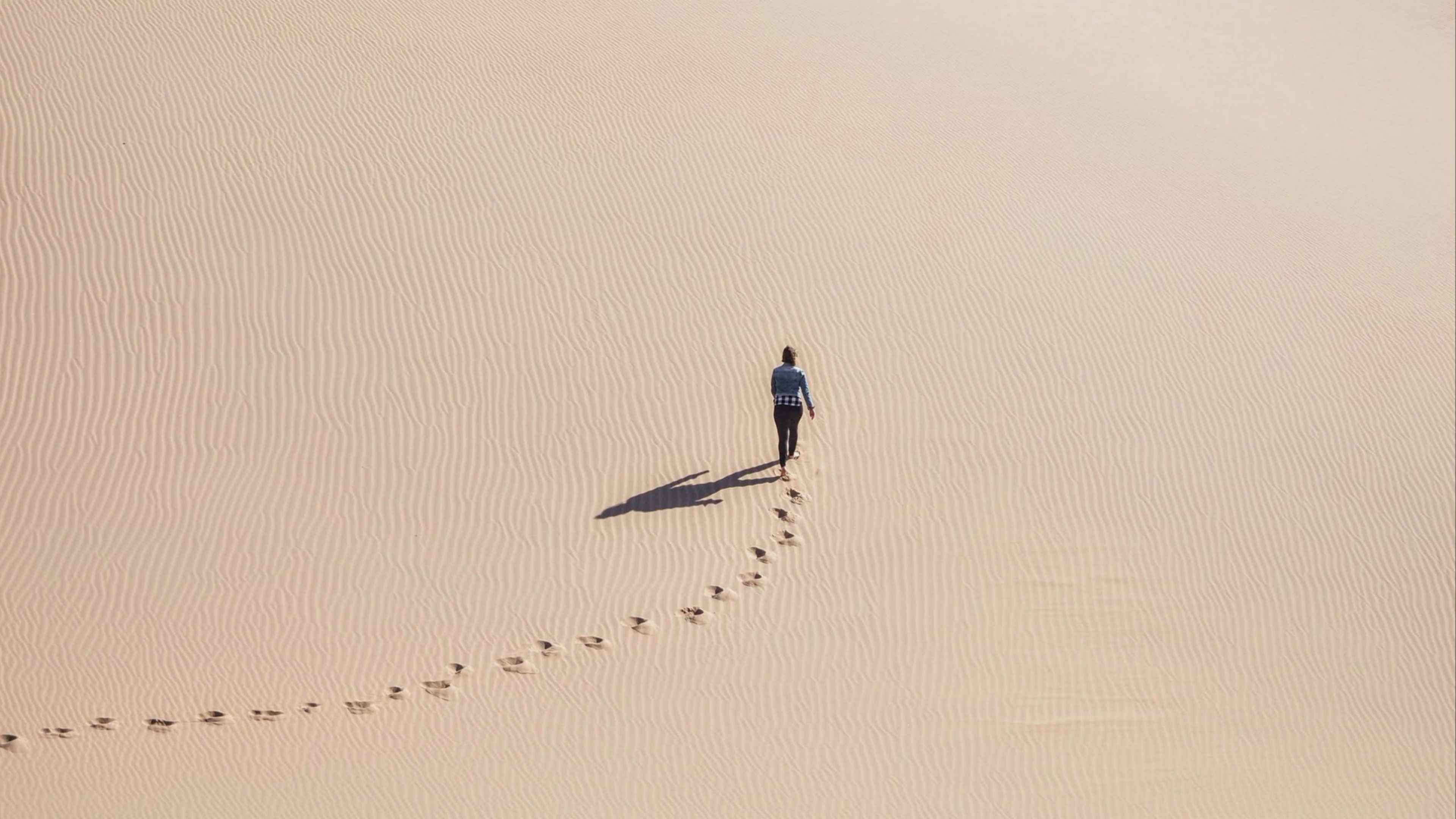 Оставив вид. Следы на песке в пустыне. Идущие по пустыне. Человек в пустыне. Человек идет по песку.