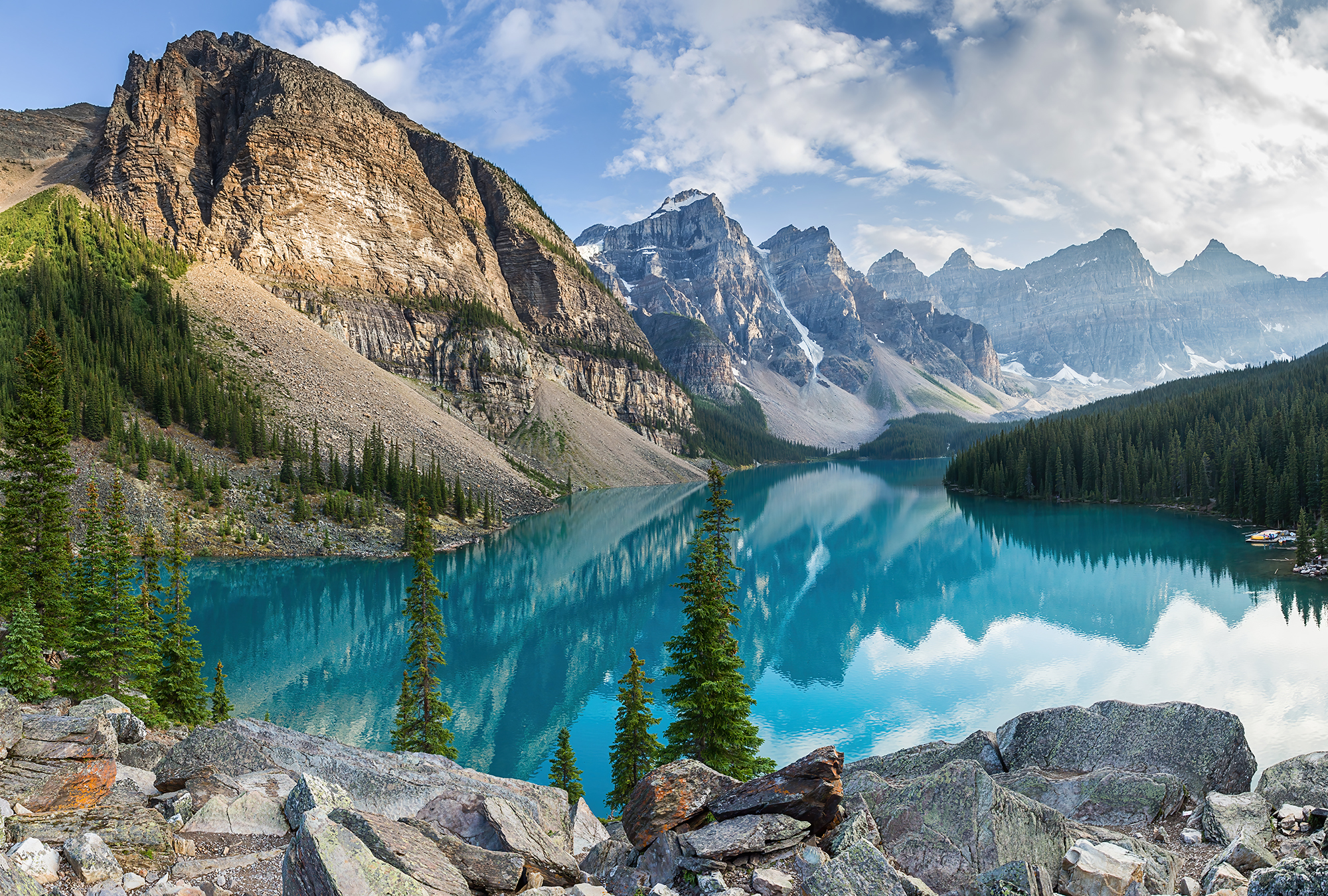 Горное озеро отличается особенной красотой. Ледниковое озеро Морейн, Канада. Озеро Морейн с панорамой скалистых гор в Канаде.