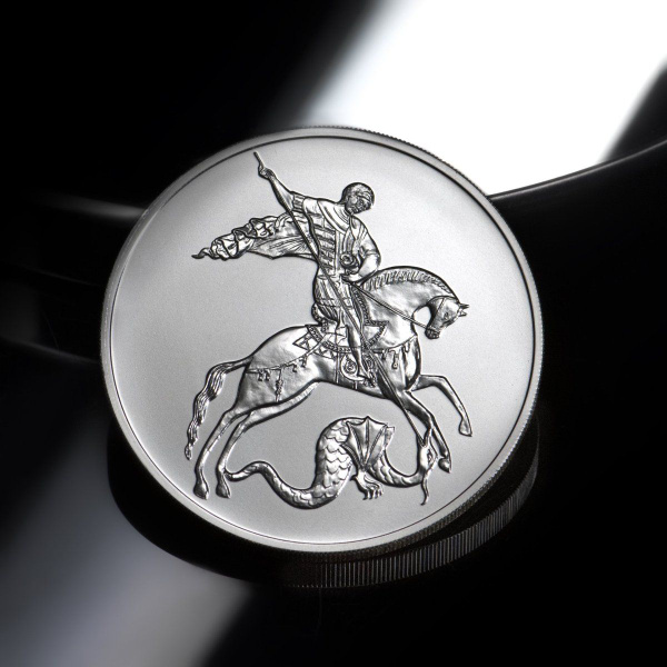 серебряная монета Георгий Победоносец на темном фоне