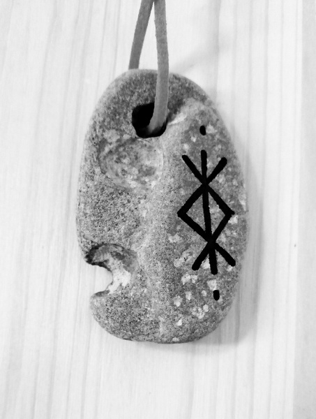древний амулет из камня на веревке