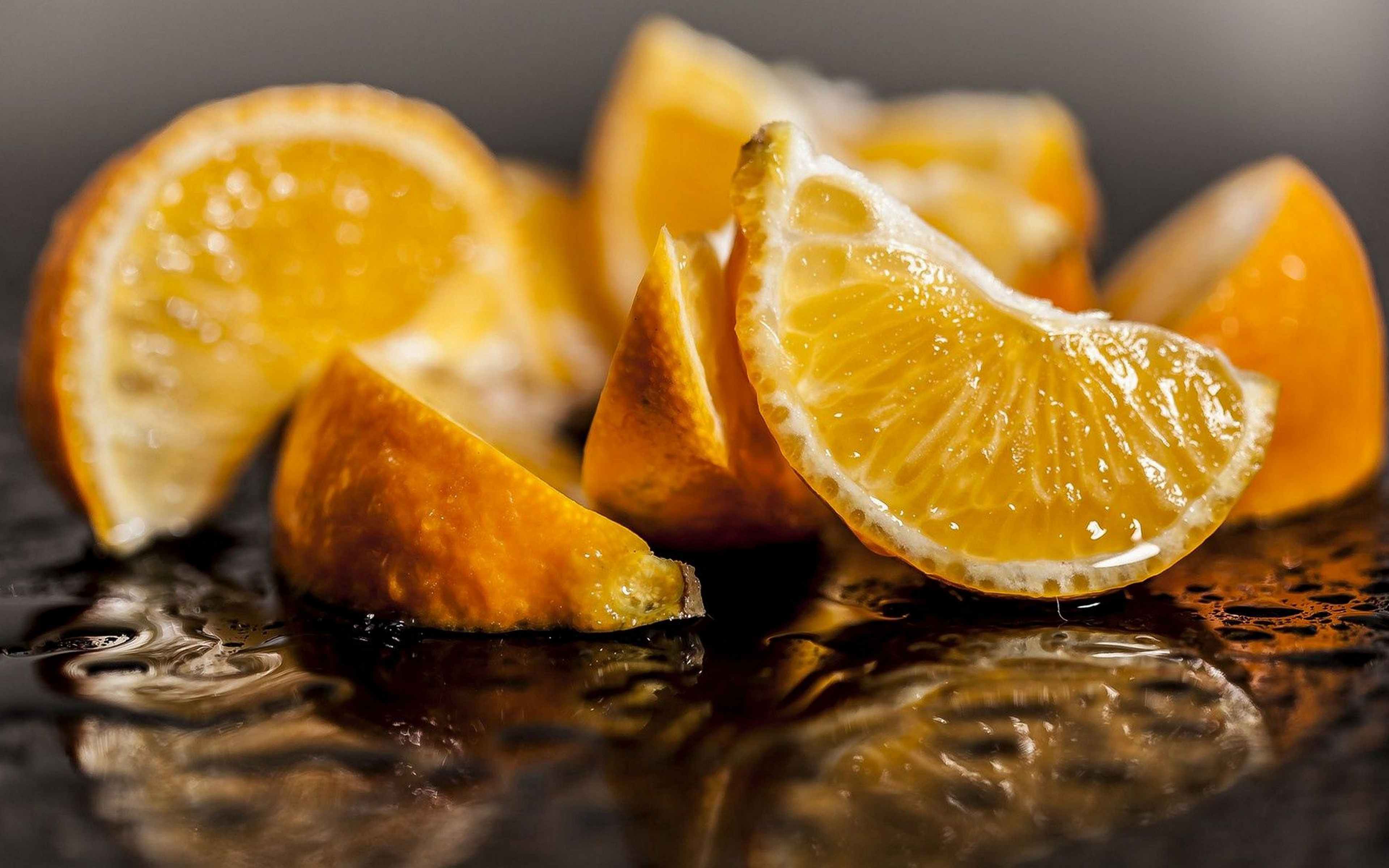 Фруктовые дольки. Апельсины на рабочий стол. Апельсины на темном фоне. Сочные фрукты. Фрукты макро.